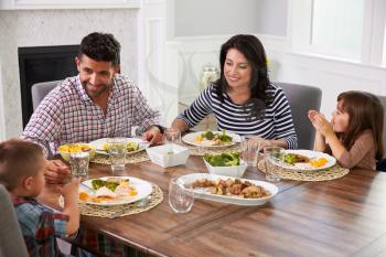 Hispanic Family Enjoying Meal At Table