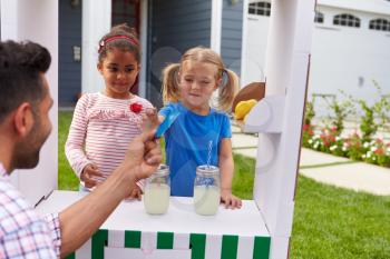 Girls Selling Homemade Lemonade From Stand At Home