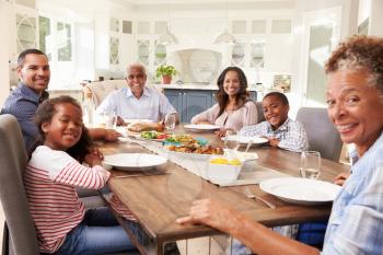 Multi generation black family at kitchen table for a meal