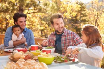 Gay Male Couple Having Outdoor Lunch With Daughters