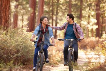 Gay Male Couple Cycling Through Fall Woodland