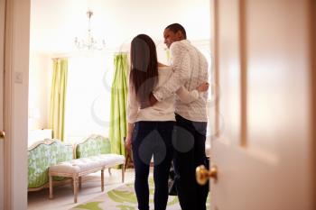 Young multi ethnic couple looking at a hotel room, back view