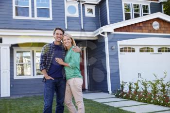 Portrait Of Couple Standing Outside House