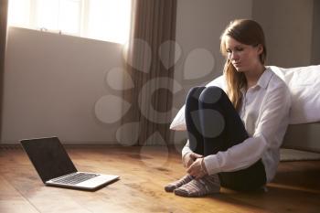 Unhappy Young Woman Being Bullied Online With Laptop