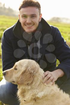 Outdoor Portrait Of Young Man With Golden Retriever