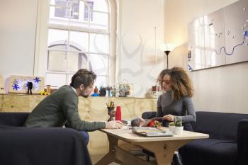 Two Designers Having Creative Meeting In Modern Office
