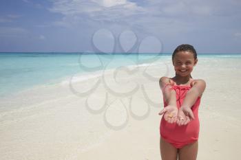 Young girl showing sea shells shes collected on the beach