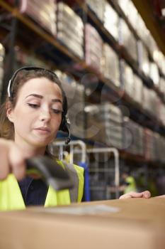 Woman uses barcode reader in a warehouse, vertical close-up