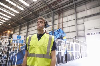 Man with reflective vest and headset standing in a warehouse