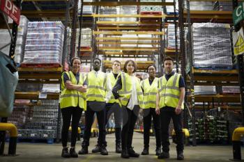 Group portrait of staff at distribution warehouse, low angle