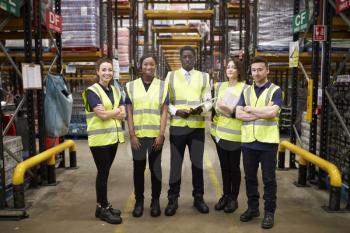 Group portrait of warehouse staff standing in the workplace