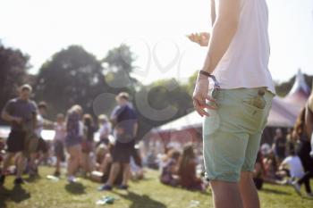 Close Up Of Man Using Mobile Phone At Music Festival
