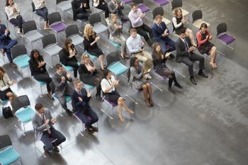 Overhead View Of Audience Applauding Speaker At Conference