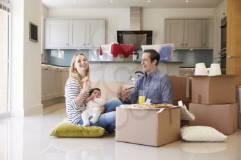 Family Celebrating Moving Into New Home With Pizza