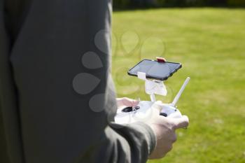 Close Up Of Man Flying Drone Quadcopter In Garden