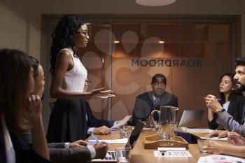 Black businesswoman addressing team at meeting, low angle