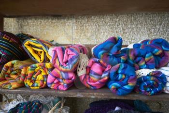 Colourful blankets on shelves in store, close up, front view