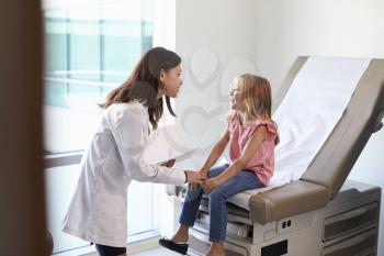 Pediatrician In White Coat With Child In Exam Room