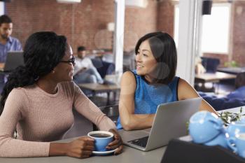 Two Businesswomen Have Informal Meeting In Office Coffee Bar