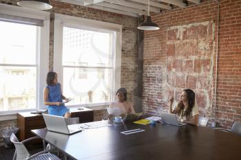 Group Of Businesswomen Working Together In Boardroom