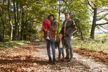 Portrait Of Family On Autumn Walk In Woodland Together