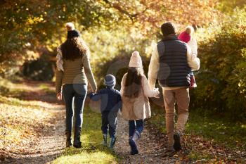Rear View Of Family Enjoying Autumn Walk In Countryside