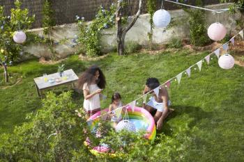Overhead View Of Family Having Fun In Garden Paddling Pool