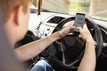 Young Man Sending Text Message Whilst Driving