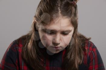Ten year old girl looking down, head and shoulders