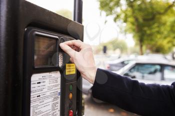 Close Up Of Man Putting Money In Parking Meter For Ticket