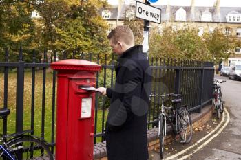 Man Posting Letter In Red British Postbox
