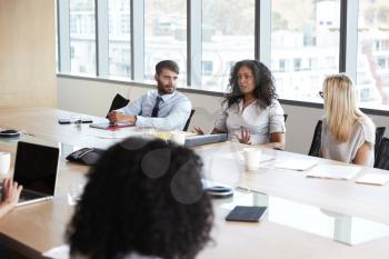 Businesswoman Leads Meeting Around Board Table
