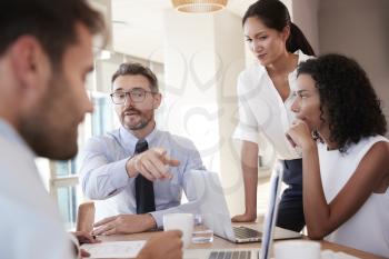 Group Of Businesspeople Meeting Around Table In Office