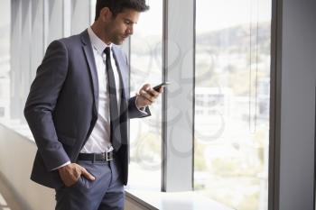 Businessman Checking Messages On Mobile Phone