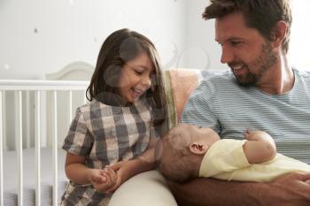 Father With Daughter And Newborn Son In Nursery