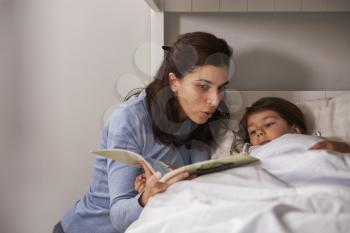Mother Reading Story To Son At Bedtime