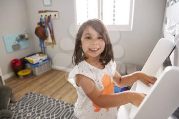 Portrait Of Girl Climbing Ladder To Bunk Bed