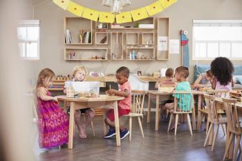 Wide Angle Shot Of Pupils Working At Tables In Montessori School