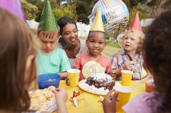 Mother With Children Enjoying Outdoor Birthday Party Together