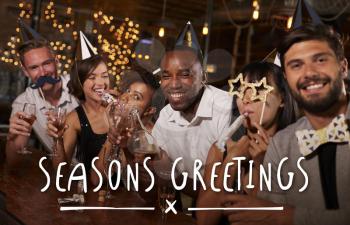 Friends at a party in a bar with Seasons Greetings message