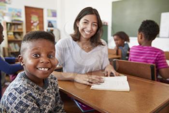 Female teacher and elementary school boy smiling to camera