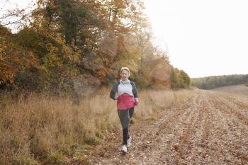 Mature Woman Running Around Autumn Field