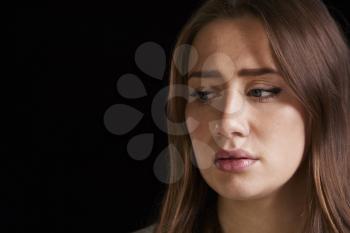 Head And Shoulders Studio Portrait Of Anxious Young Woman