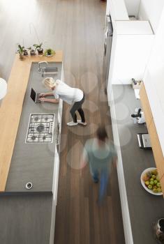 Overhead View Of Busy Couple In Modern Kitchen