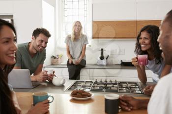 Friends Talking And Drinking Coffee In Modern Kitchen