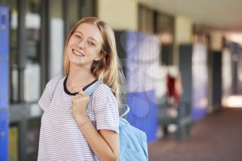 Happy white teenage girl smiling in high school corridor