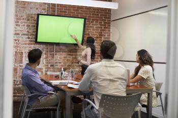 Businesswoman Standing By Screen To Deliver Presentation