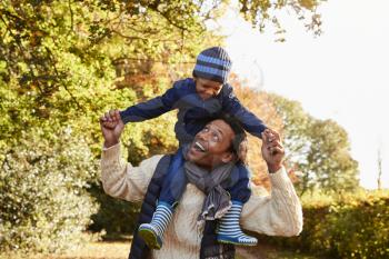 Autumn Walk With Father Carrying Son On Shoulders