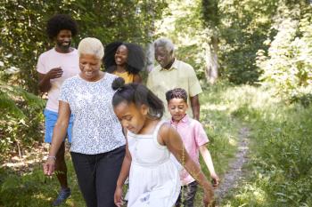 Black girl walks with grandma and family in forest, close up