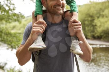 Close Up Of Father Carrying Son On Shoulders On Walk By River